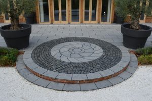 Farley Black step to lawn with bespoke circle kit and Granite setts.
