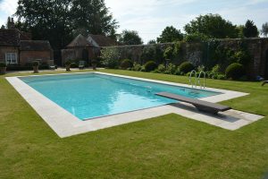 Travertine pool copings on a walled garden pool.
