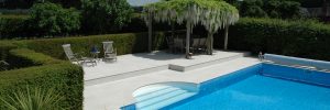 Portland Cream Porcelain non slip with bespoke roman end pool copings and matching paving by cranbourne stone ltd